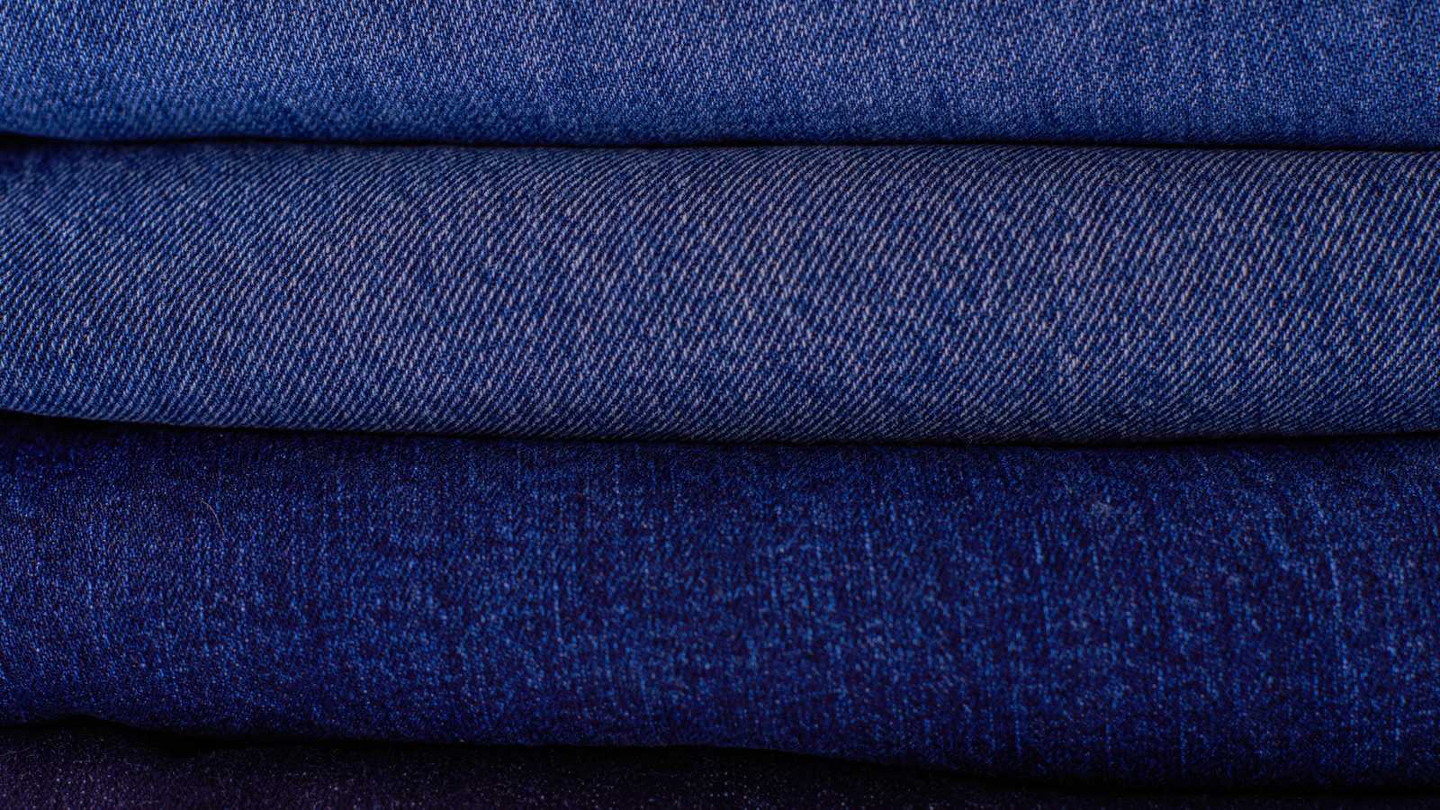 03 jea Gros plan sur une toile de denim brut indigo pliée, trame visible