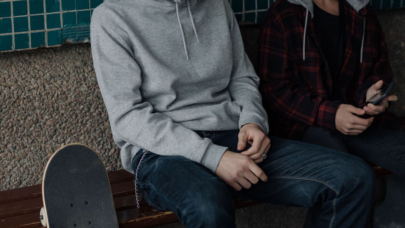 06 hoo Personne assise en hoodie gris avec une chemise à carreaux par-dessus