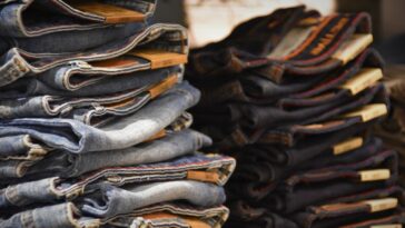 Piles de jeans de délavages différents empilées sur un étal de marché