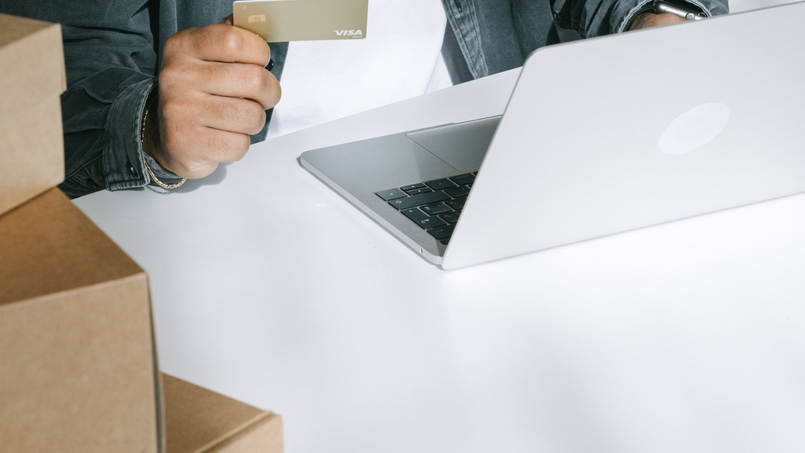 09 ach Personne avec une carte bancaire, un ordinateur portable et des cartons de livraison