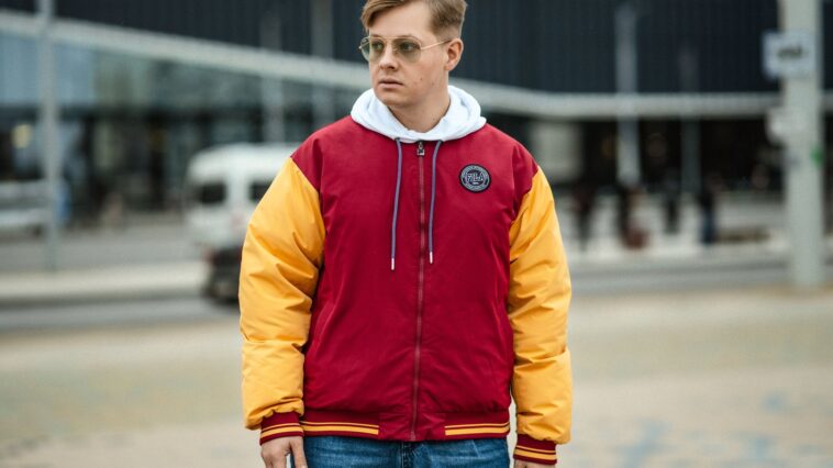 Homme en veste teddy rouge et jaune portée sur un hoodie blanc